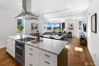 Where function meets the view. The kitchen opens effortlessly to the living area, keeping hosts connected and sightlines clear—all while drawing your eye to the treetops and territorial vistas beyond.