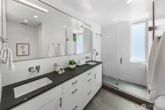 Serene, streamlined, spa-inspired. The primary bath features dual vanities, a walk-in rain shower, and natural light—combining luxury and simplicity in a space designed for everyday renewal.