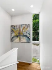 Anchored by light and form. This lower-level stairwell frames a quiet composition of art, wood, and landscape—highlighting the home’s thoughtful transitions and ever-present relationship to nature.    Ready for the next photo!