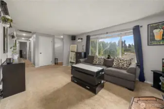 Natural light pours through the oversized front-facing window, perfectly complementing the warmth of the wood stove. A peaceful and inviting spot for cozy evenings or enjoying views of the front yard.