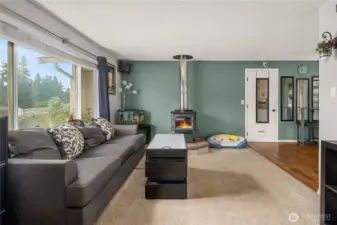 Enjoy the seamless flow from the cozy living room into the dining and kitchen areas. This angle highlights the practical layout and warm transition from carpet to hardwood flooring, enhancing both comfort and function.