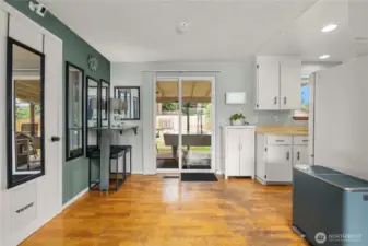 This inviting dining area is filled with natural light from the sliding glass door, offering direct access to the covered back patio—perfect for indoor-outdoor entertaining. The hardwood flooring adds warmth, while the adjacent wall offers space for additional storage or decor.
