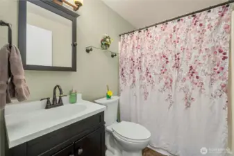 This full bath includes an updated vanity, coordinating fixtures, and warm, neutral finishes. A combination tub and shower offers everyday convenience, and the space is well-lit for functionality and comfort.