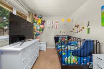This cozy secondary bedroom features a large window that fills the space with natural light and offers a view of the backyard. Neutral walls and carpet make it easy to personalize, and the layout is ideal for use as a bedroom, playroom, or guest space.