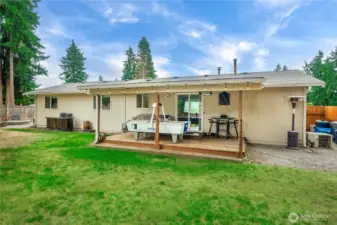 Enjoy the benefits of a covered back patio—ideal for year-round relaxation or entertaining. The string lights add a cozy ambiance, while the spacious wood deck offers plenty of room for outdoor seating, dining, or recreation. Just off the deck, the large, level backyard provides green space for pets, play, or gardening.