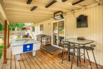 Step directly from the interior onto this inviting, covered patio with a wood plank floor and overhead heating unit for added comfort. The layout offers a versatile footprint for outdoor dining or lounge setups, all with easy access to the backyard through the sliding glass door.