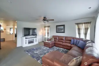 Living room has plenty of windows for natural light and ceiling light/fan cambo