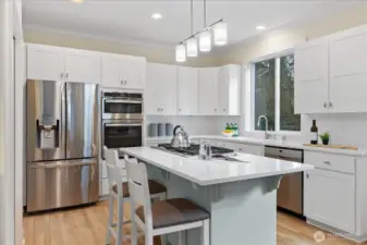Newly refinished kitchen cabinets provide ample storage space, featuring an eat-in counter and a large pantry located to the right.