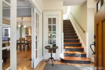 The formal entry greets you, with the living  room to the left, and the stairs to the upper  level. Floors are oak hardwood on the main  floor and fir on the stairs and upper level.  The ceilings are high, and there are so many  beautiful details, like these multi paned  window panels in the entry.