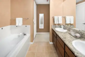 Primary bath has double sinks, soaking tub, shower, toilet.