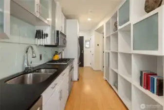 Kitchen offers quality, well-maintained stainless steel aplpiances, easy to clean glass panel backsplash with modern appeal. Black honed quartz counters