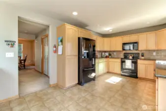 As you pass through the kitchen, the utility room is the door to the right and follows through to the garage. There is a half bath to the left, across from the utility room.