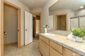 This view shows through the bathroom door thee walk in closet to the left of the door then the entry door further to lead to the hallway.