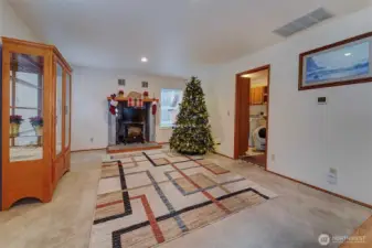 The family room off the kitchen. The 'fireplace' area- the unit is an electric fireplace and can either stay or go with sellers. Utility/laundry room off to the right.