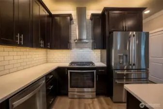 Stainless steel, quality appliances including a gas range. Upgrades to the kitchen also include a full tiled backsplash and custom fan.