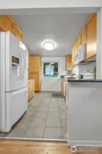 The kitchen has tiled floors, granite counters and custom cabinets.