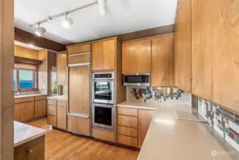 Subzero fridge, custom wood cabinetry, mid-century tile backspalsh, double oven- this kitchen has served many meals with friends & family.