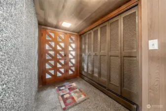 Custom entry way with unique front door. The exposed aggregate concrete wall adds appeal & hydronic radiant heating warms guests as they are welcomed.