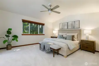 Primary bedroom with vaulted ceilings and fan