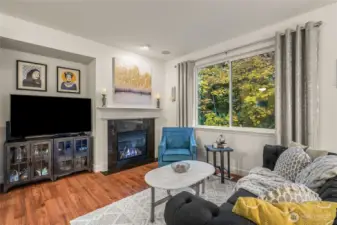 Bright open-concept living room with gas fireplace and hardwood floors