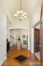 Welcome guests in the grand entry, featuring soaring vaulted ceilings and hardwood floors with granite inlay.