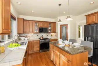 The kitchen features new (2024) smart LG appliances and a walk-in pantry — plus a built-in central vacuum with a convenient toe kick dustpan right on the island.