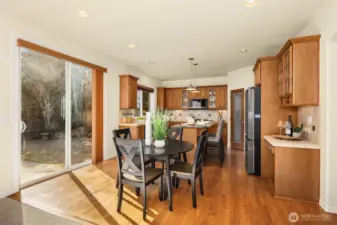 Another view of the well-appointed kitchen and casual dining area, with the greenbelt and backyard just beyond the slider.