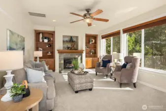 The light-filled family room features a gas fireplace, custom built-ins, and peaceful views of the private backyard.