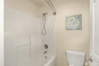 The shower/tub and toilet are tucked away from the vanity — making it easy for two people to share the space at once.