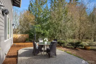 The patio backs to a lush, private greenbelt — a serene outdoor retreat freshly landscaped with new mulch and grass seed