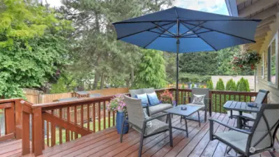 Newly stained entertainment deck overlooks the lush greenery in your private back yard.
