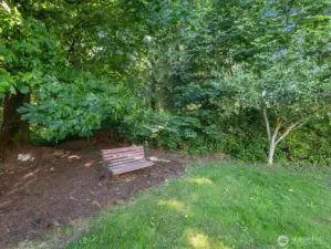 Beautiful sprawling yards create outstanding outdoor spaces, with    mature trees, many blooming flowers, & large wooded area.