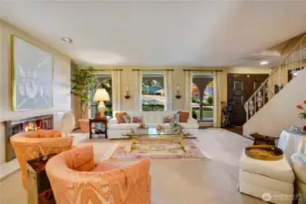 Living room is framed by floor-to-ceiling picture windows, flooding the home with radiant natural light.