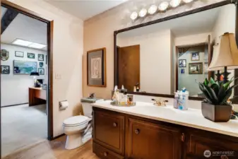 Den or bedroom has seamless access to a half bathroom through a sleek pocket door.