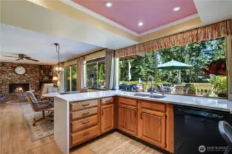 This vibrant kitchen and living room bursts with natural light streaming through expansive windows, showcasing stunning views of the 7th green and fairway.