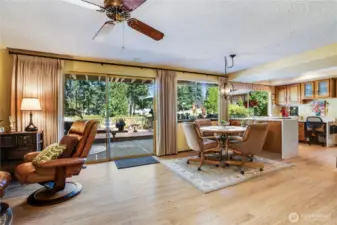 This home strikes a perfect balance of indoor-outdoor living with floor-to-ceiling sliding glass doors that seamlessly connect a spacious, light-filled interior to a sprawling deck overlooking lush greenery.