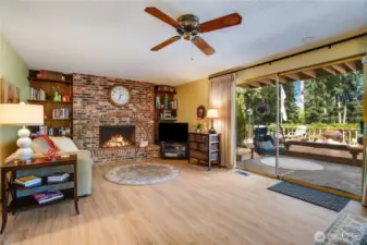 This inviting space radiates warmth, with a striking stone fireplace as the room’s cozy centerpiece, complemented by plush seating, soft lighting, and rich wooden accents.