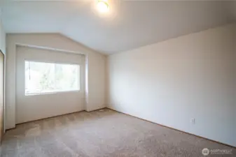 Spacious primary bedroom with vaulted ceilings.