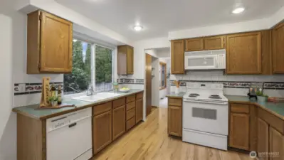 Bright and stylish kitchen featuring rich wood cabinetry, ample counter space, and access to both dining spaces.