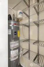 Brand new Rheem 50 gallon water heater located in closet at entry with plenty of shelving for storage.