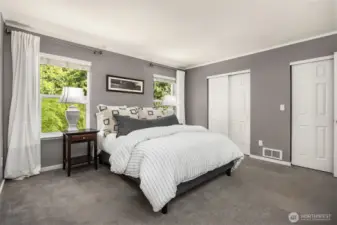 Primary suite with two closets and a beautiful view of the serene backyard