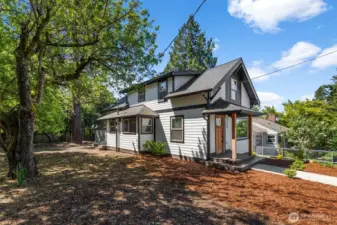 Front and side view of the exterior with mature growth.