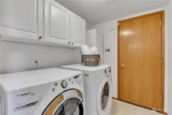 Main floor utility room includes washer & dryer. Storage closet to the right of this photo.