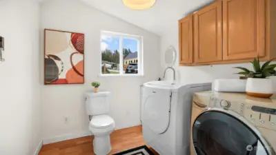 Convenient laundry space with the added bonus of a half bathroom, combining function and style.