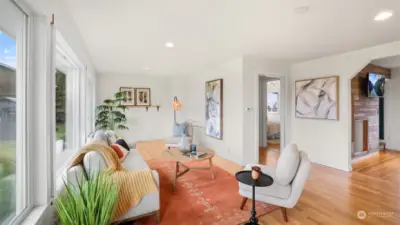 Clean and modern living room features large windows and recessed lighting.