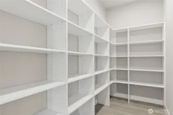 Spacious walk-in pantry with custom built-in shelving offers ample storage for dry goods, kitchenware, and small appliances—an ideal complement to the home’s gourmet kitchen.