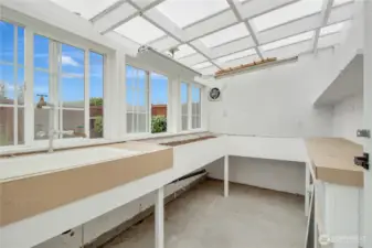 Light and bright greenhouse with fan, lots of windows, built in potting table too!