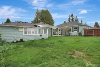 Completely fenced backyard has alley access.