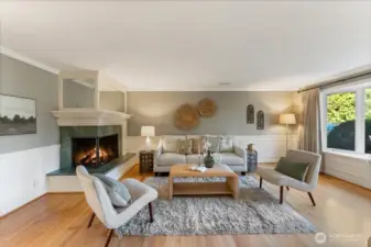 Spacious living room with oversized bay windows and a wood-burning fireplace provides an inviting setting for living and entertaining.