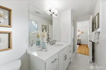 The primary bathroom has been refreshed with a new, timeless vanity featuring a quartz countertop, complemented by fresh paint.